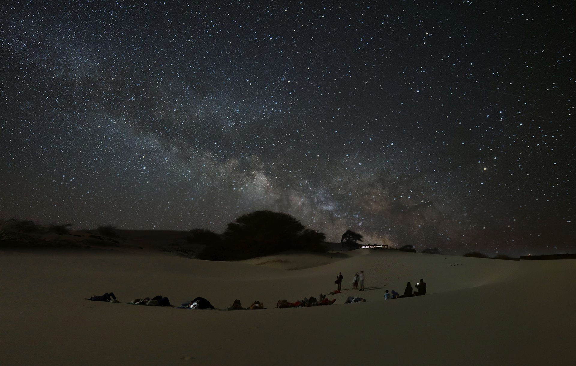 Gruppo in osservazione delle stelle sotto la Via Lattea nel deserto